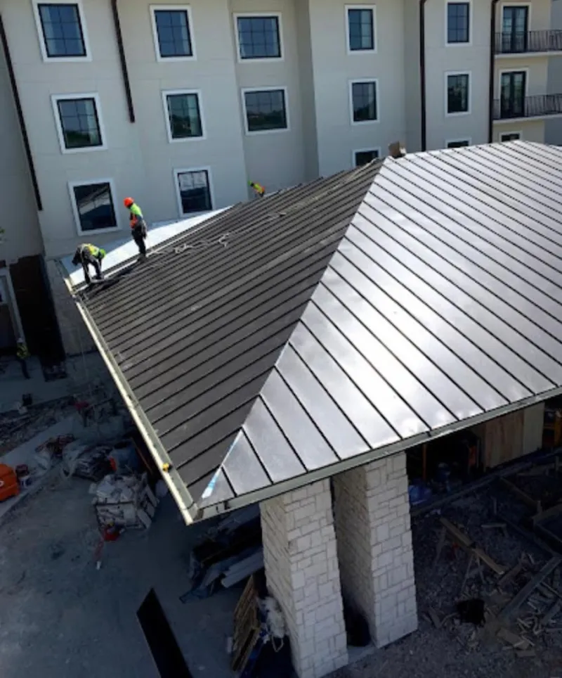 Crew installing standing seam metal roof panels on a commercial project in Annapolis